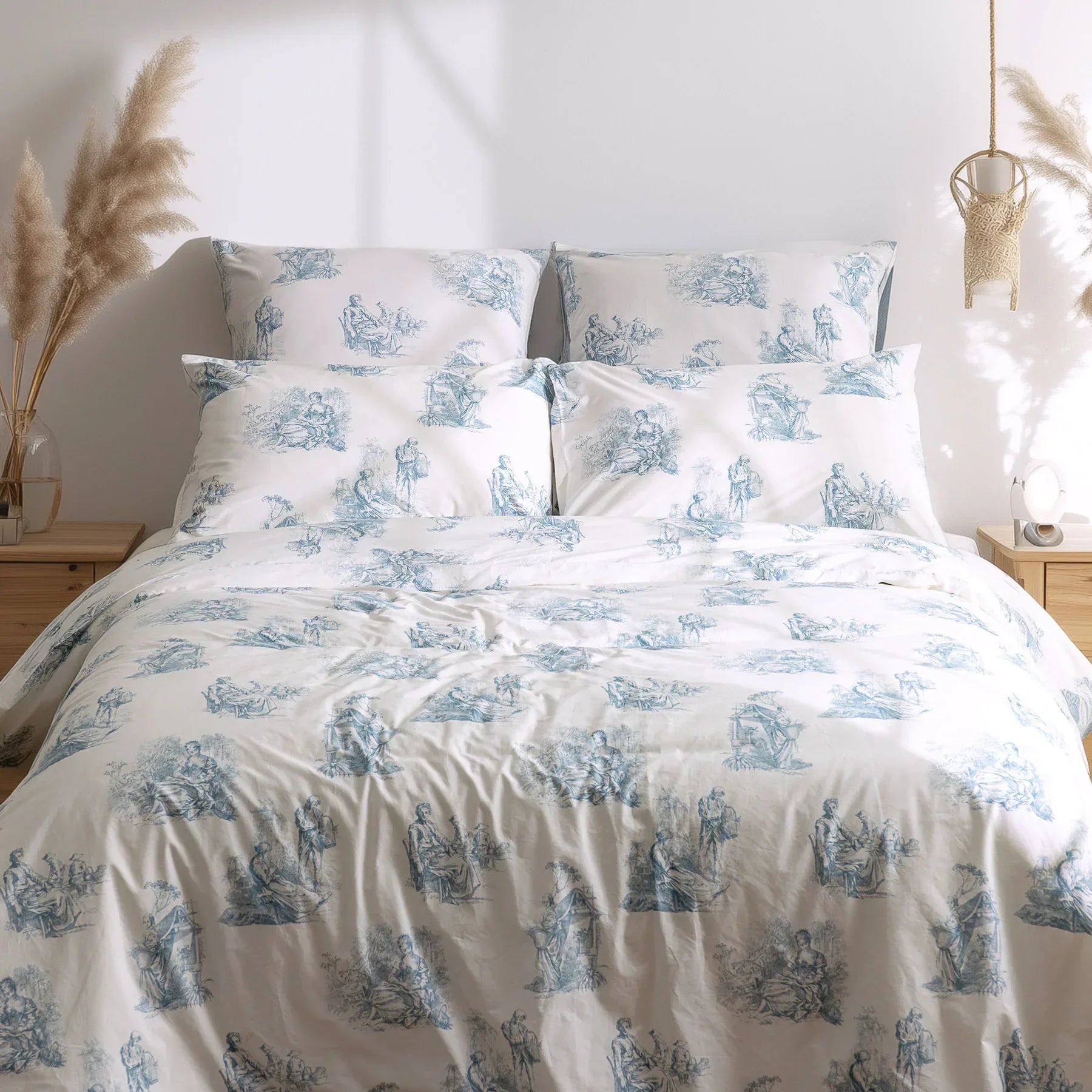 Blue and white toile de Jouy duvet cover set on bed in bright modern bedroom